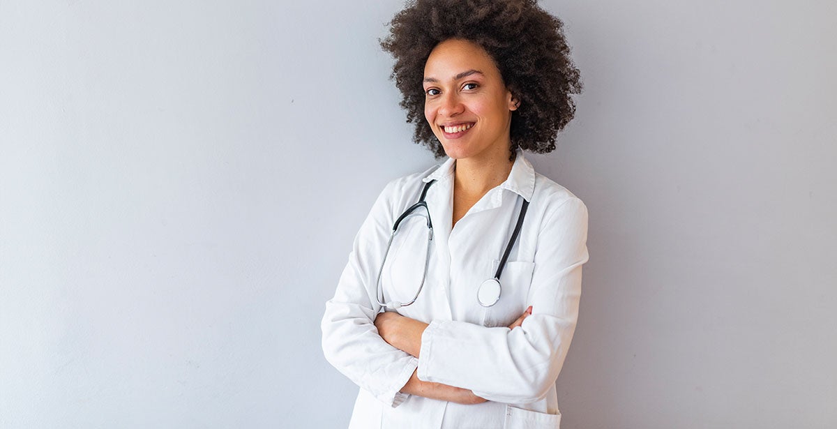 Successful nurse practitioner leaning against the wall