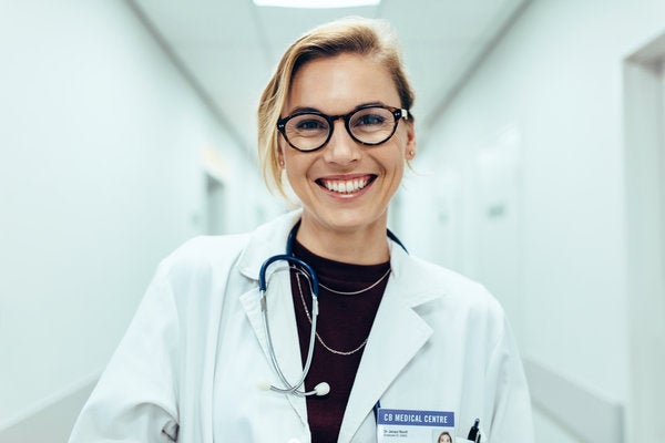 Family nurse practitioner smiling in hospital corridor