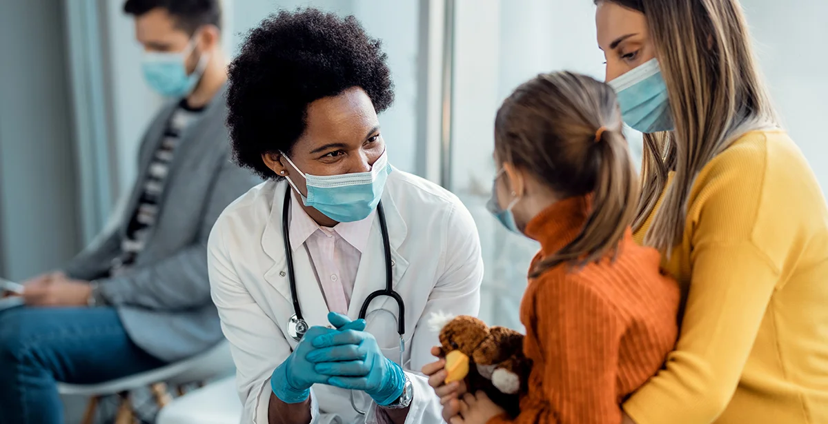 Family nurse practitioner speaking with young patient and her mother