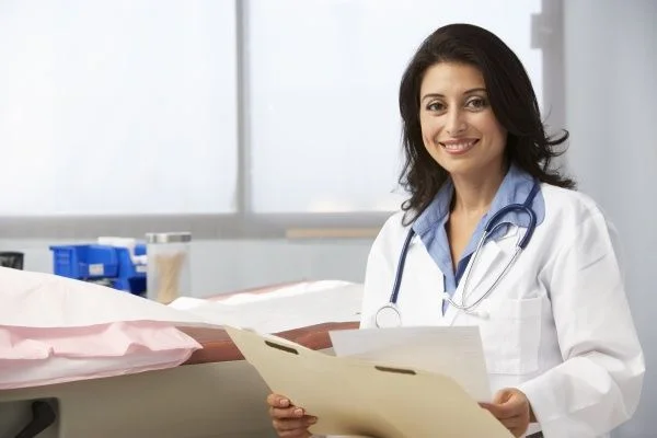 Smiling female nurse practitioner filing patient records in a private practice office