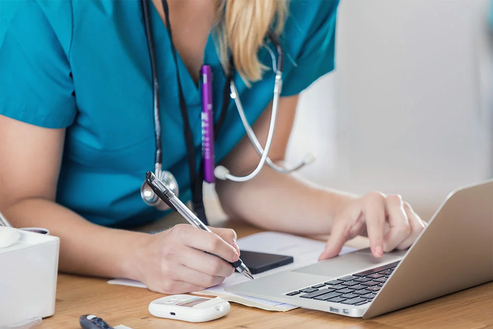 Female Nurse Practitioner helping patients on computer