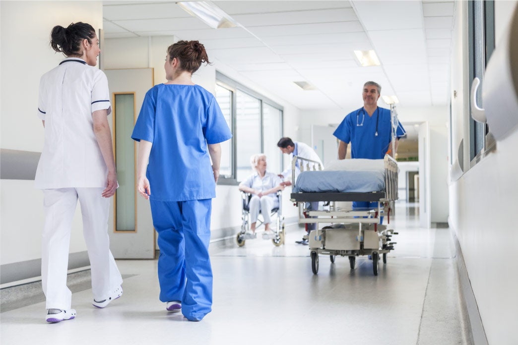 Healthcare workers in a busy hospital corridor