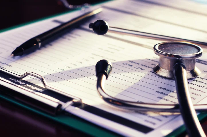 Close-up of a stethoscope, pen, and medical clipboard