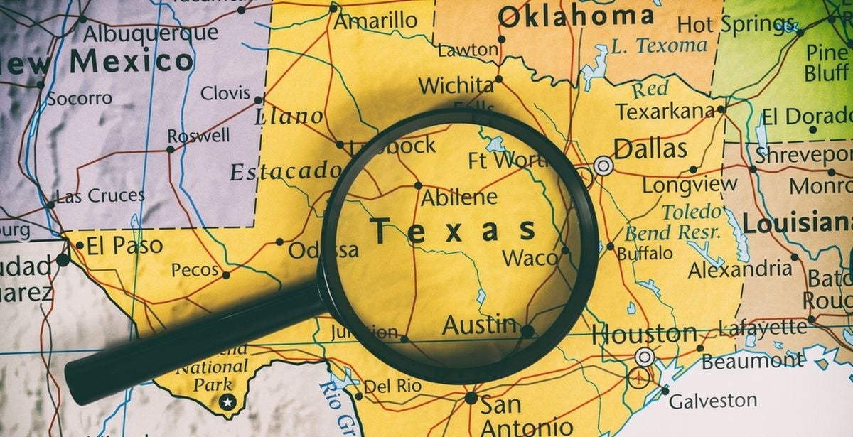 Magnifying glass on top of a map of Texas