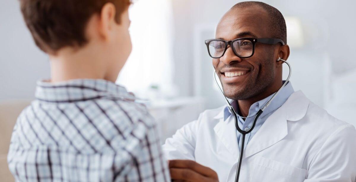 Male nurse practitioner interacting with young boy patient