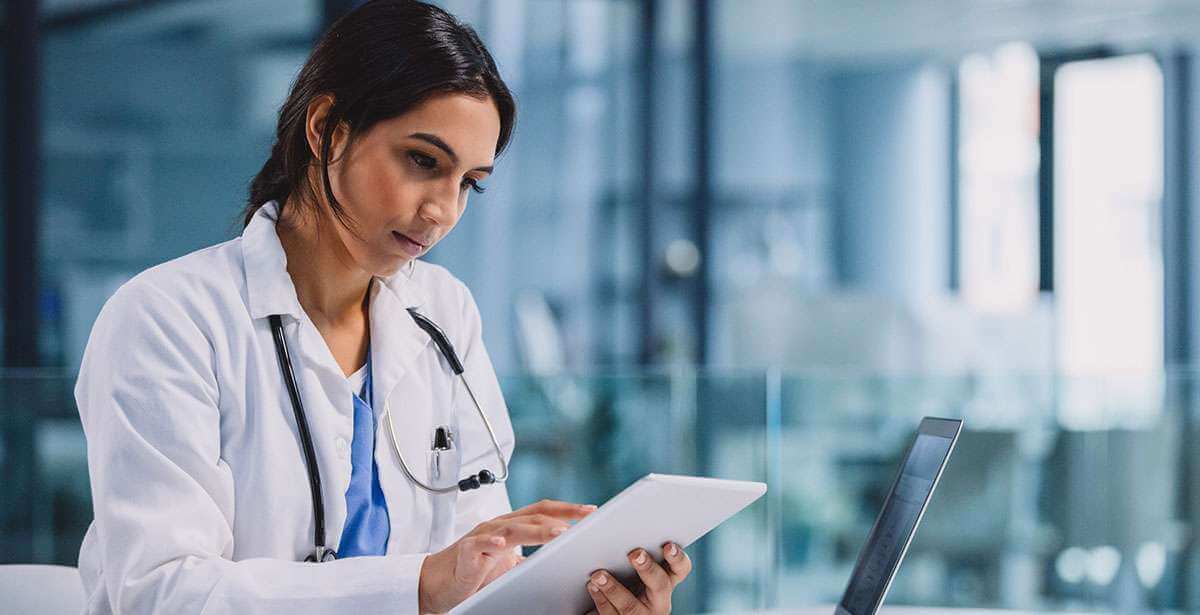 Telehealth Nurse Practitioner helping patients on a tablet and laptop.