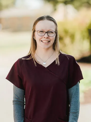 nurse graduate smiling on campus