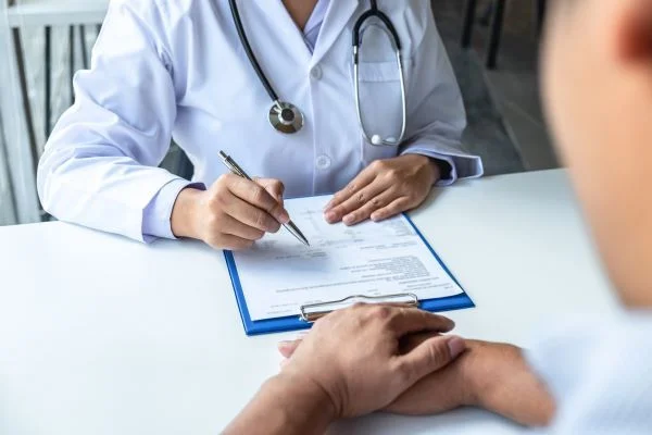 Close-up of a nurse practitioner filling out a patient's medical file