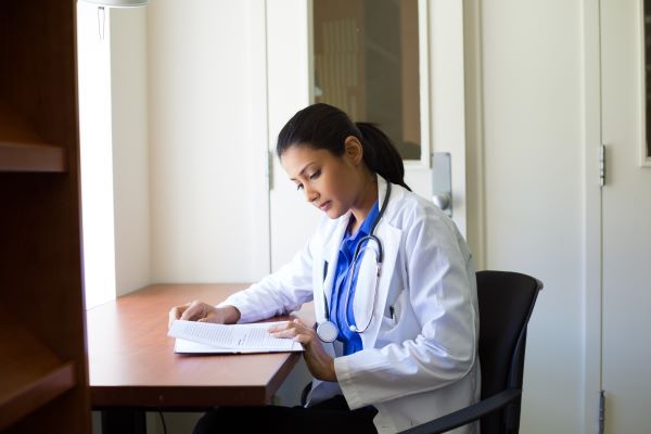 Female nurse practitioner reviewing medical files at her desk