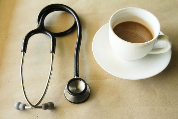 A stethoscope beside a mug of coffee